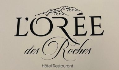 Logo de l'hôtel-restaurant L'Orée des Roches avec un fond montagneux.